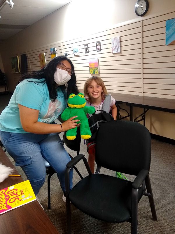 volunteer and kid with stuffed frog